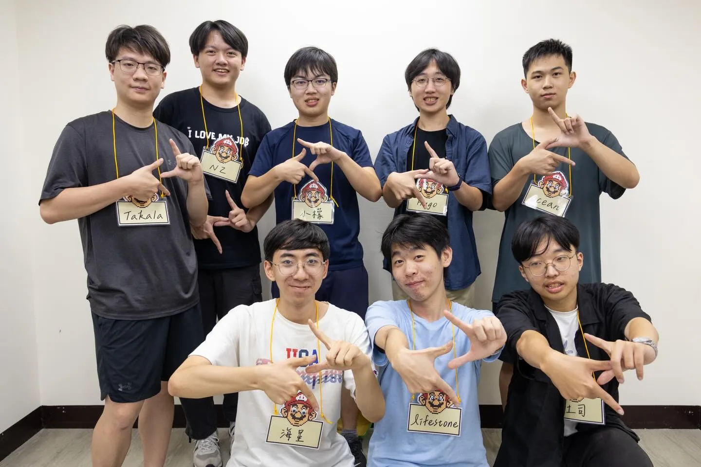 2025 臺師大資工營教學組 8 位工作人員的合照,每人掛著寫有名字的名牌。