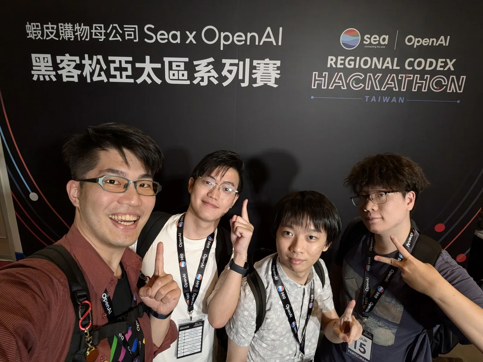 Weave-In 四位隊員在 Sea x OpenAI Regional Codex Hackathon Taiwan 背板前的自拍合照,脖子上掛著參賽證。